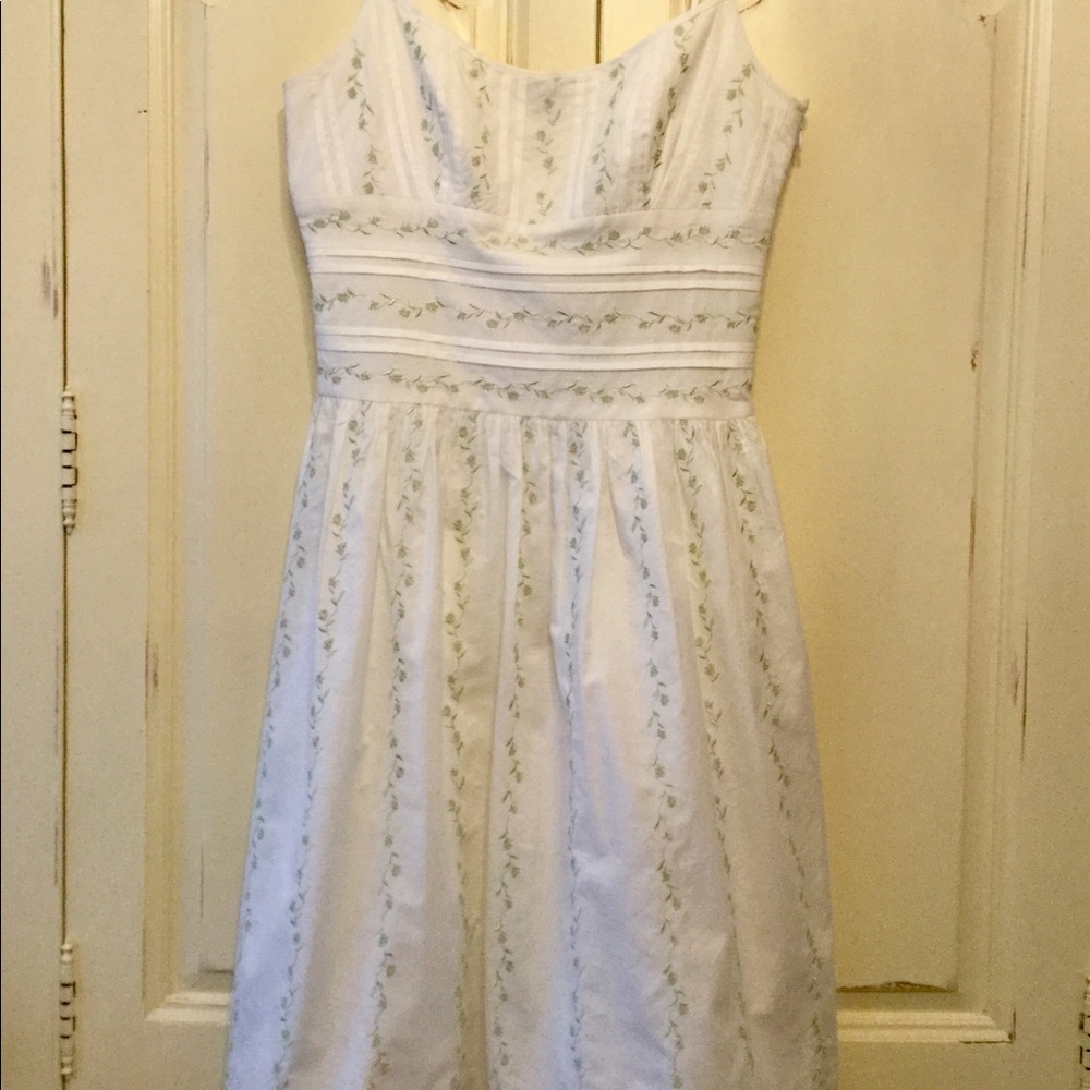 White dress with floral embroidery.